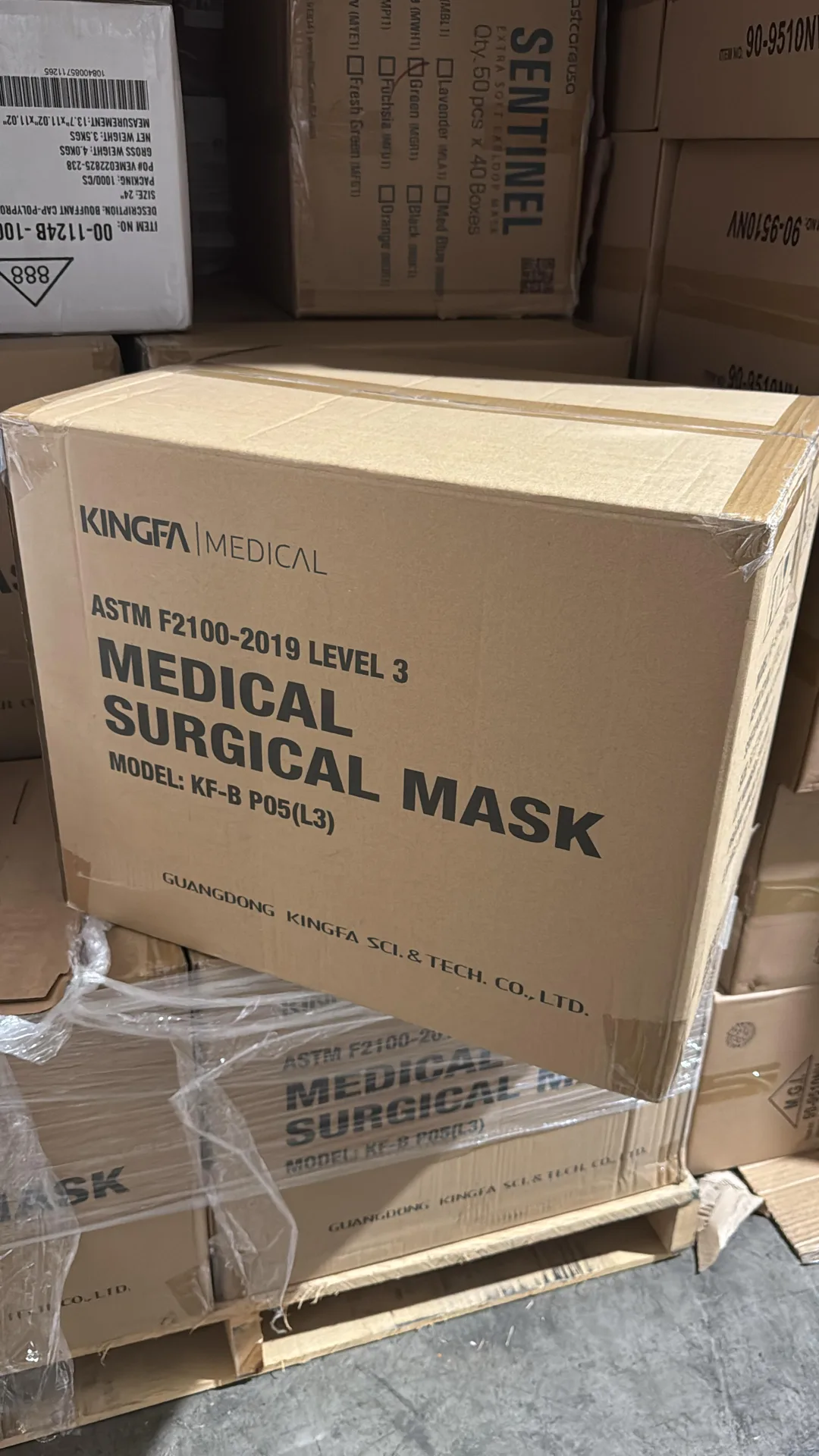 Shipping cases of Kingfa ASTM Level 3 medical surgical masks on a pallet at receiving